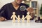 Young african american judge with magnifying glass looking on family wood figure