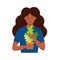 Young African American lady florist standing holding a flowerpot with houseplant urban design. Basic stylish beautiful