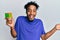 Young african american man with beard playing colorful puzzle cube intelligence game celebrating achievement with happy smile and