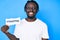 Young african american man with braids holding hashtag paper looking positive and happy standing and smiling with a confident