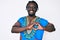 Young african american man with braids wearing traditional africa tshirt smiling in love showing heart symbol and shape with hands