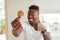 Young african american man eating chocolate chips cookies happy with big smile doing ok sign, thumb up with fingers, excellent