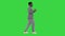 Young african american man in grey clothes and glasses grooving while walking on a Green Screen, Chroma Key.