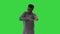Young african american man in grey clothes and glasses grooving while walking on a Green Screen, Chroma Key.