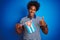 Young african american man holding Cuba Cuban flag standing over isolated blue background happy with big smile doing ok sign,