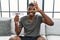 Young african american man holding diet banner sitting on the sofa at home smiling happy doing ok sign with hand on eye looking