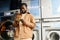 Young African American man marking time of washing in his smartphone