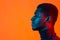 Young african-american man in neon light. Male portrait side view. Concept of human emotions, facial expression. Orange