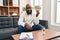 Young african american man psychologist holding dollars at psychology center