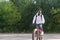 A young African-American man rides a bicycle in nature