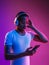 Young african-american man`s listening to music in neon light