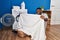 Young african american man smiling washing clothes at laundry room