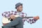 Young African American man tuning guitar over light blue background