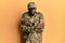 Young african american man wearing army uniform shaking and freezing for winter cold with sad and shock expression on face