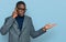 Young african american man wearing business clothes and glasses confused and annoyed with open palm showing copy space and