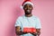 Young african american man wearing Santa hat holding gift