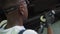 A young African-American mechanic applies car polishing paste. Recover the car from damage. A black man is getting ready