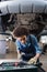 young african american mechanic standing beneath