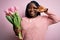 Young african american plus size woman with braids holding bouquet of pink tulips flower Doing peace symbol with fingers over