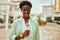 Young african american reporter woman using microphone at the city