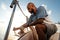 Young african american sailor tying ropes on sailboat in the sea on sunset