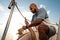 Young african american sailor tying ropes on sailboat in the sea on sunset