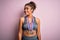 Young african american sporty girl doing sport winning medals over isolated pink background looking away to side with smile on