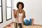 Young african american woman with afro hair at the gym training with battle ropes smiling with happy face looking and pointing to