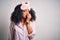 Young african american woman with afro hair wearing sleeping eye mask and pink pajama looking stressed and nervous with hands on