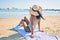 Young african american woman on back view sitting on towel at the beach