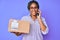 Young african american woman with braids holding delivery box calling assistance smiling with a happy and cool smile on face