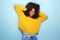 Young african american woman covering her ears and screaming on blue background