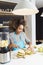 Young African American woman cutting fruit in the kitchen