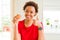 Young african american woman eating chocolate chips muffins happy with big smile doing ok sign, thumb up with fingers, excellent