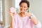 Young african american woman eating pink sugar marshmallows donut very happy pointing with hand and finger