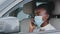 Young african american woman ethnic black girl afro lady driver wearing medical protective face mask sitting in car