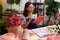 Young african american woman florist reading notebook with doubt expression at flower shop