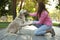 Young African-American woman and her Golden Retriever dog in park