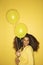 Young African-American woman holding balloons.