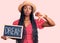 Young african american woman holding blackboard with dream word with angry face, negative sign showing dislike with thumbs down,