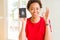 Young african american woman holding Canadian passport doing ok sign with fingers, excellent symbol