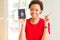Young african american woman holding Canadian passport very happy pointing with hand and finger to the side