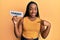 Young african american woman holding comedy word paper pointing finger to one self smiling happy and proud