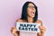 Young african american woman holding happy easter message paper angry and mad screaming frustrated and furious, shouting with