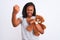 Young african american woman holding teddy bear over isolated background annoyed and frustrated shouting with anger, crazy and