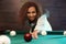 Young African-American woman playing Russian billiard