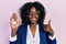 Young african american woman real state agent holding key of house smiling happy and positive, thumb up doing excellent and