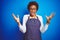 Young african american woman shop owner wearing business apron over blue background celebrating crazy and amazed for success with