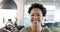 A young African American woman smiles brightly in a business office setting