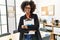 Young african american woman smiling confident holding clipboard at office